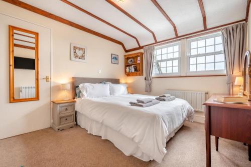 a bedroom with a large white bed and two windows at 2 Bed in Padstow oc-p00398 in Saint Merryn