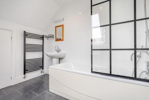 a white bathroom with a tub and a sink at 2 Bed in Padstow oc-p00398 in Saint Merryn