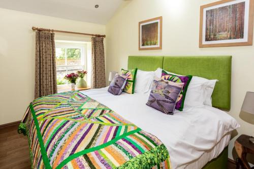 ein Schlafzimmer mit einem großen Bett mit grünem Kopfteil in der Unterkunft 2 Bed in High Fremington oc-ds375 in Reeth
