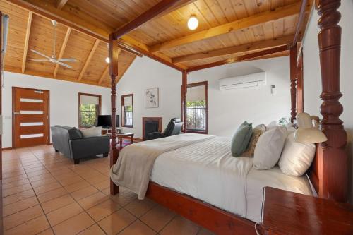 a bedroom with a large bed and a living room at Mountainside Villa One in Halls Gap