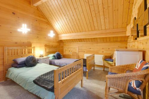 a bedroom with two beds in a log cabin at 4 Bed in Wadebridge oc-p00066 in Little Petherick