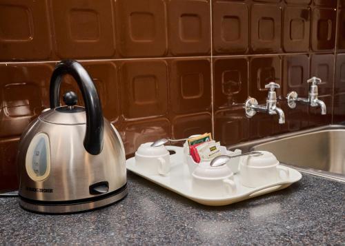 a tea kettle sitting on a counter next to a sink at Hotel Waterbuck in Nakuru