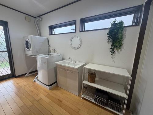 a bathroom with a sink and a washing machine at SerenityBlueAmami in Tatsugo