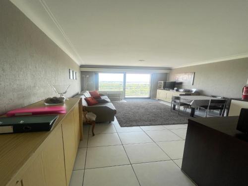 a large living room with a couch and a table at Apartment with Pool and Sea View in Middelkerke