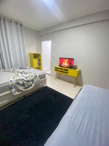 a bedroom with two beds and a tv on a table at Seja Bem-Vindos, sinta-se em Casa ! in São Lourenço