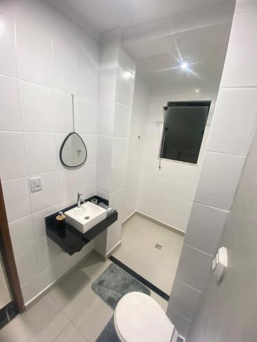 a white bathroom with a sink and a toilet at Seja Bem-Vindos, sinta-se em Casa ! in São Lourenço