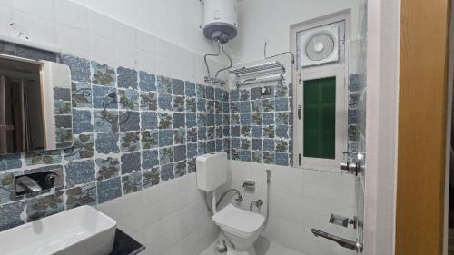 a bathroom with a toilet and a sink and a mirror at Aashvika Homes in Katrain