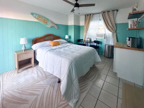 a bedroom with a bed with a surfboard on the wall at Oasis Palms Resort in St. Pete Beach