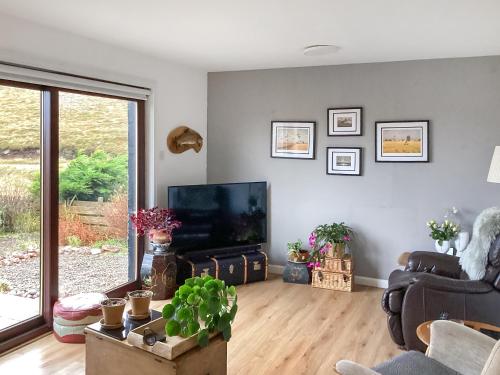 a living room with a television and a couch at At Last in Rhiconich