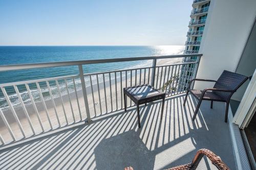 a balcony with two chairs and the ocean at Romantic Honey Moon Suite, Direct Oceanfront,Pools in Myrtle Beach