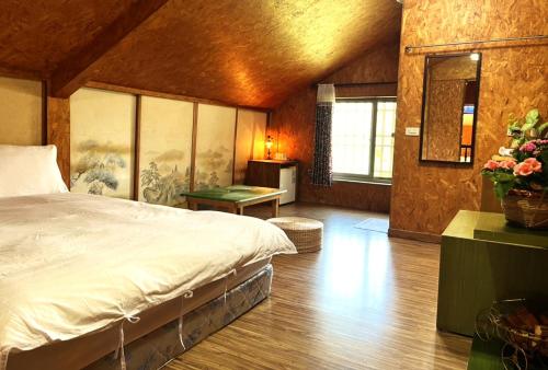 a bedroom with a large bed in a room at 十畝田山莊 in Chishang