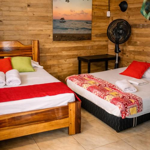 a bedroom with two beds and a fan at Playa Terküa hotel in Nuquí