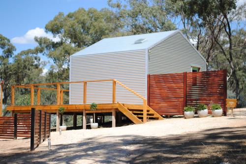 a large metal building with a ramp and a wooden deck at Cosy Tents - Daylesford in Yandoit