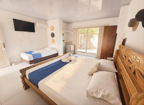 a bedroom with two beds and a flat screen tv at Tintipan Hotel in Tintipan Island