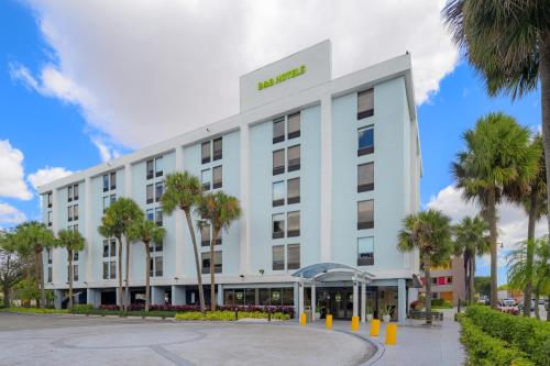 a hotel building with palm trees in front of it at B&B Hotel Miami Airport in Miami