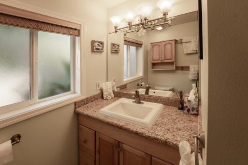 a bathroom with a sink and a mirror at Maui Beach House B & B in Kahana