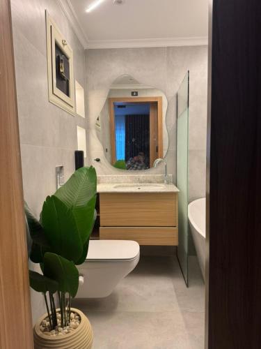 a bathroom with a sink and a toilet and a mirror at Luxury 2BR Pool View Apartment Hotel Style in New cairo