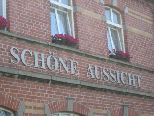 a sign on the side of a brick building at Hotel Schöne Aussicht in Weißenfels
