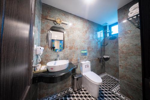a bathroom with a sink and a toilet and a mirror at Nature Hotel and Spa Ha Noi in Hanoi