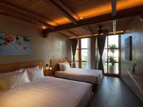 a bedroom with two beds and a large window at The Pink Boutique Hotel in Da Lat