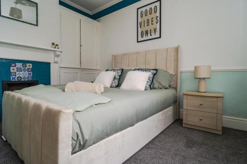 a bedroom with a large bed and a table with a lamp at Upper Grosvenor Suite in Royal Tunbridge Wells