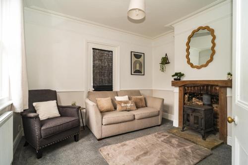 a living room with a couch and a chair and a fireplace at Upper Grosvenor Suite in Royal Tunbridge Wells