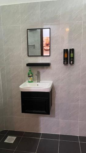 a bathroom with a sink and a mirror on the wall at Paradise Homestay Marang in Marang