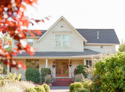 a white house with a red door at Napa Farmhouse Inn in St. Helena