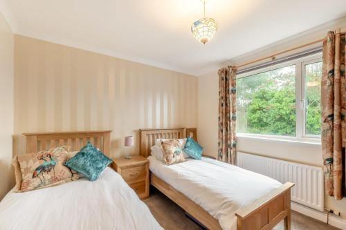 two beds in a room with a window at 2 Bed in Wooler oc-l29429 in Wooler
