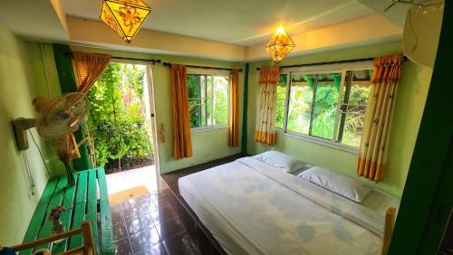 a bedroom with a bed in a room with windows at nam jai pai in Ban Wiang Nua