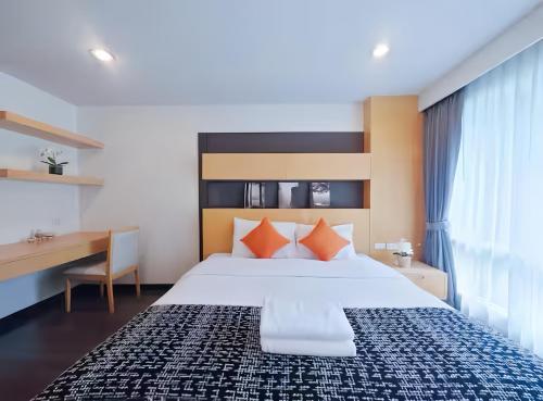 a bedroom with a large bed with orange pillows at Residence One Bangkok in Bangkok