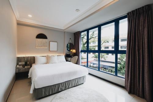 a bedroom with a large bed and a large window at Harbour Ville Hotel in Singapore