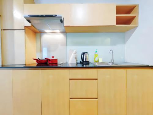 a kitchen with wooden cabinets and a sink at Residence One Bangkok in Bangkok