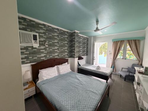 a small bedroom with two beds and a window at Lucenas B&B near Maravilla White Sand Beach in Maraat