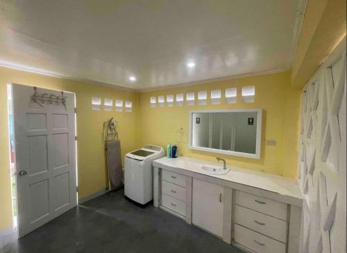 a bathroom with a sink and a washing machine at Lucenas B&B near Maravilla White Sand Beach in Maraat