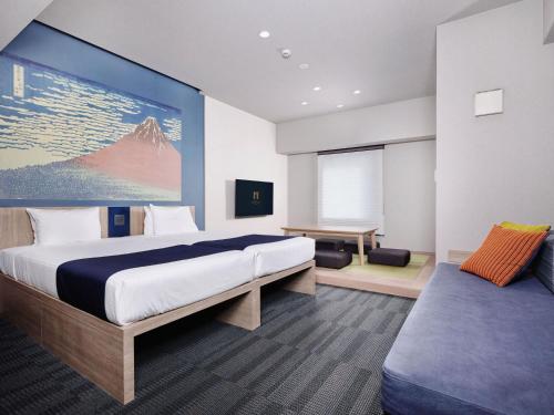 a hotel room with a large bed and a desk at MONday Apart Ueno Shinokachimachi in Tokyo