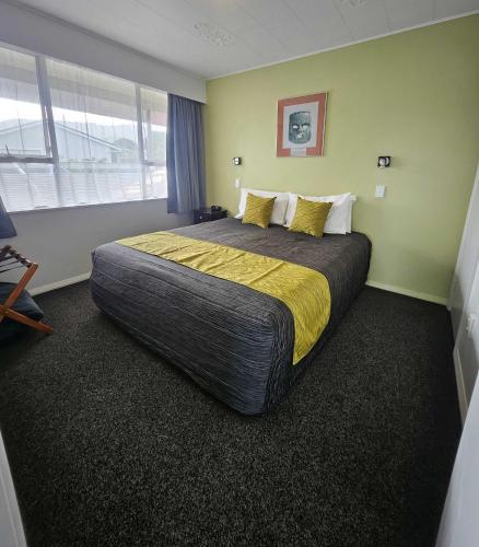 a bedroom with a large bed in a room at Scenicland Motels in Greymouth