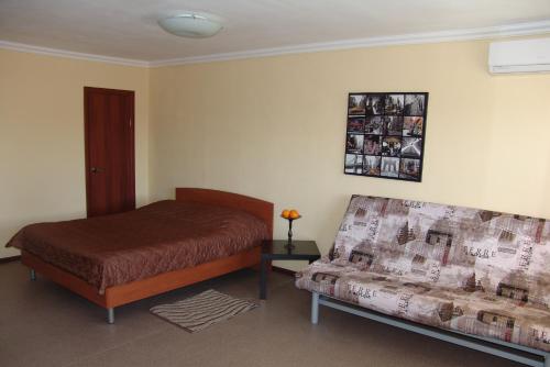 エカテリンブルクにあるАпартаменты Челюскнинцев 29のベッドルーム(ベッド1台、ソファ付)