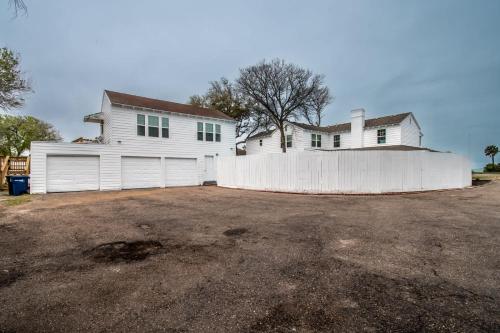 a white house with a white fence in front of it at Coastal Oasis - Beautiful Ocean Views Awaits in Corpus Christi