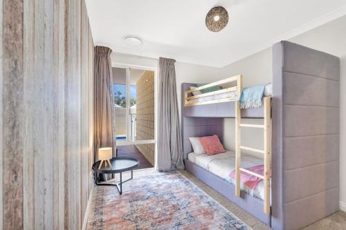 a small bedroom with bunk beds and a table at Premium Large Cosy Home with Private Pool in Perth