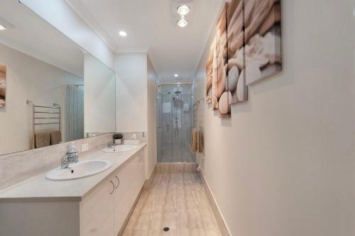a white bathroom with two sinks and a shower at Premium Large Cosy Home with Private Pool in Perth
