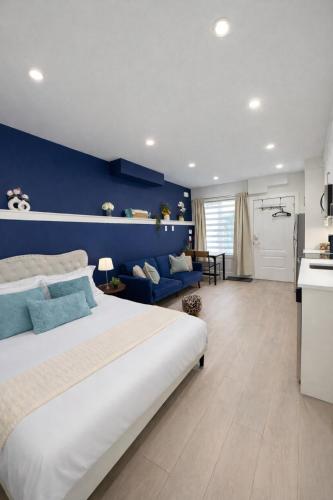 a bedroom with a large bed and a blue wall at Cozy Private Suite near YVR Airport in Vancouver
