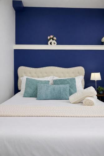 a blue bedroom with a white bed with blue walls at Cozy Private Suite near YVR Airport in Vancouver