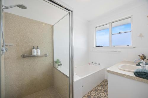 a white bathroom with a shower and a sink at Alma Beach Haven in North Haven