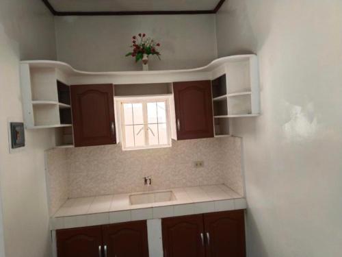 a kitchen with a sink and a window at Tayud Hotel by Hiverooms in Liloan