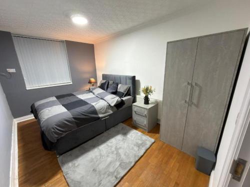 a bedroom with a bed and a large cabinet at Kings Lodge in Manchester