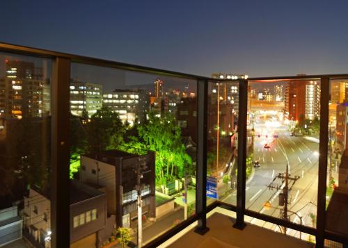 a view of a city at night from a balcony at Prime Suites Tokyo in Tokyo