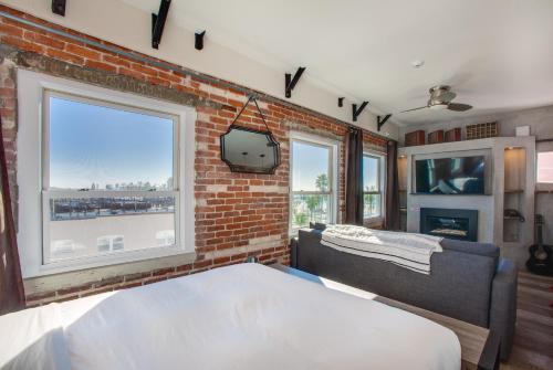 a bedroom with a brick wall and a bed and a tv at Venice V Hotel in Los Angeles