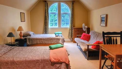 a bedroom with two beds a couch and a window at Domaine des sentiers in Mansonville
