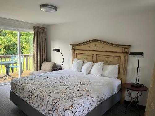 a bedroom with a large bed and a balcony at Lyn Aire Motel - Lake George in Lake George